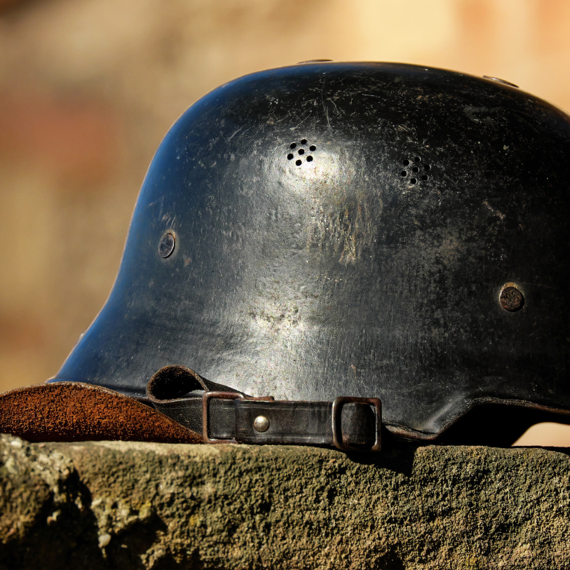 A helmet sitting ontop of a rock.