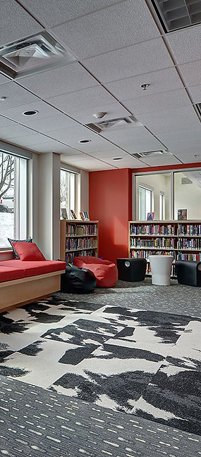Youth lounge with red benches, patterned rug, snowy view