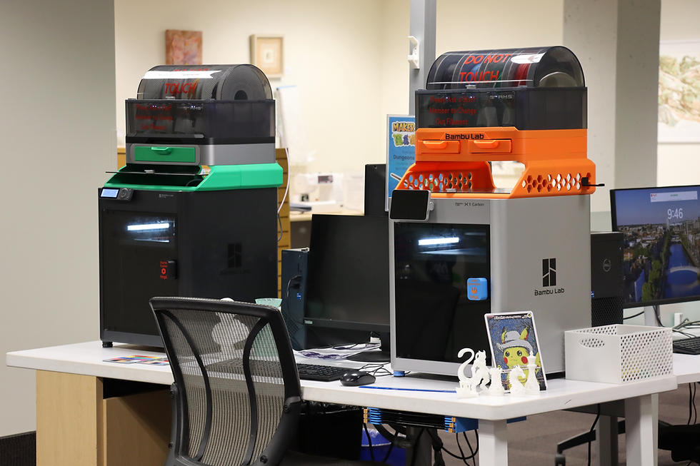 Two 3D Printers on top of a desk with a desktop computer between them.