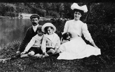 Vintage family photo with two children and a dog by a lake