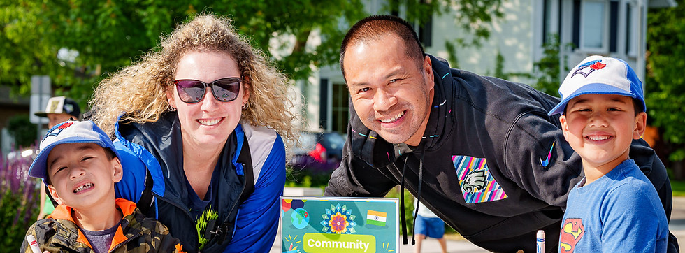 Smiling family at the outdoor Summer Reading Challenge event.