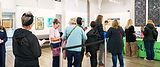People line up for a book signing in a gallery.