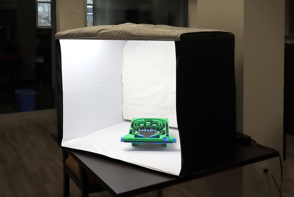 A product photography booth on a desk with its light shining onto a game.