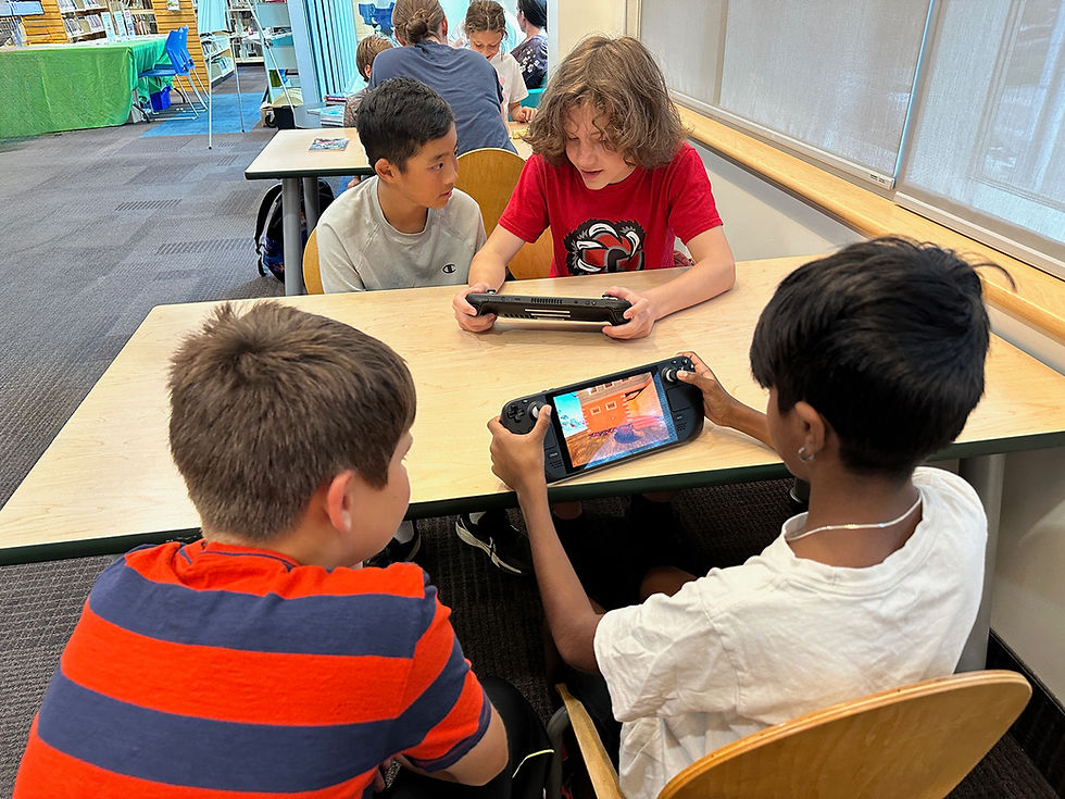 Children playing handheld video games at a table