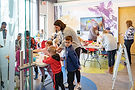 Adults and children doing activities in a colorful room