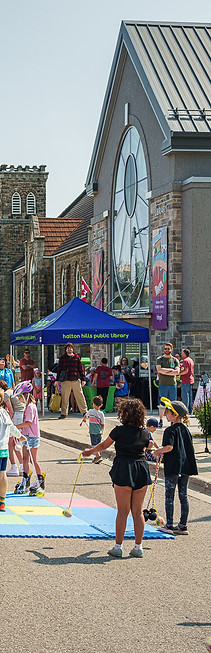 Children and families enjoying outdoor activities at a community street event.