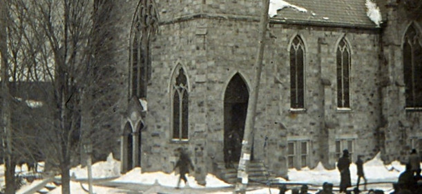 Old stone church, snowy winter day, people outside