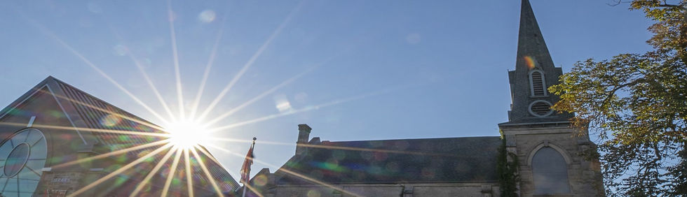 Historic building with steeple and bright sunburst