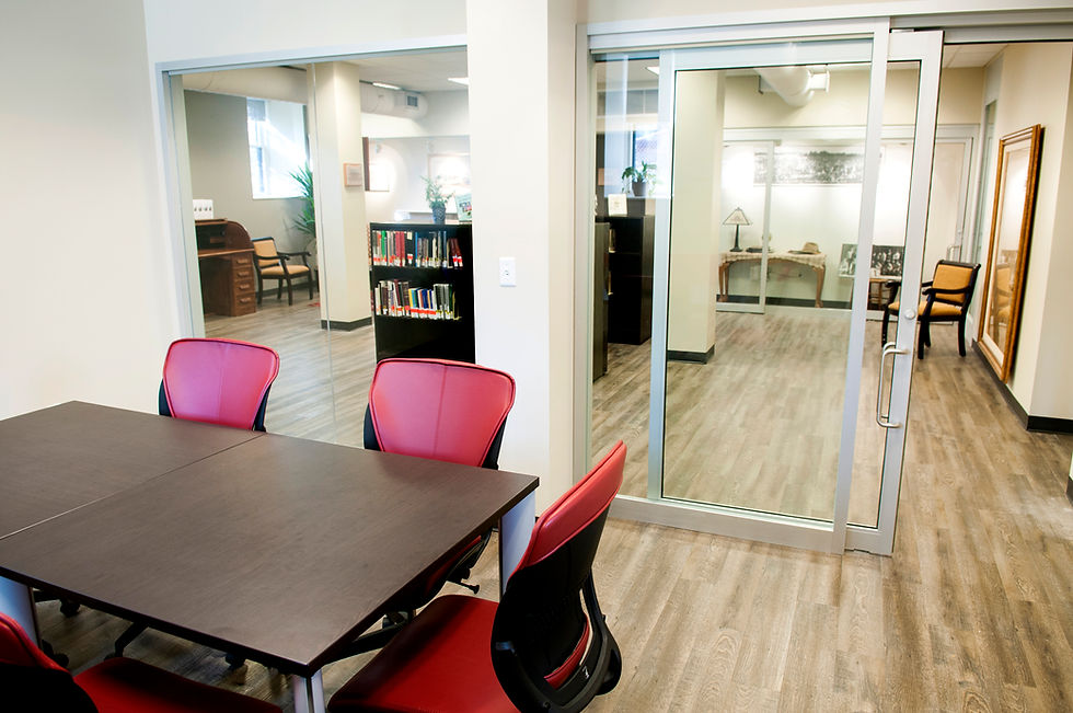 Conference room with red chairs, dark table, and glass door