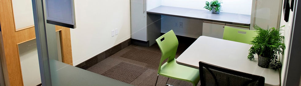 Study room with white table and green chairs